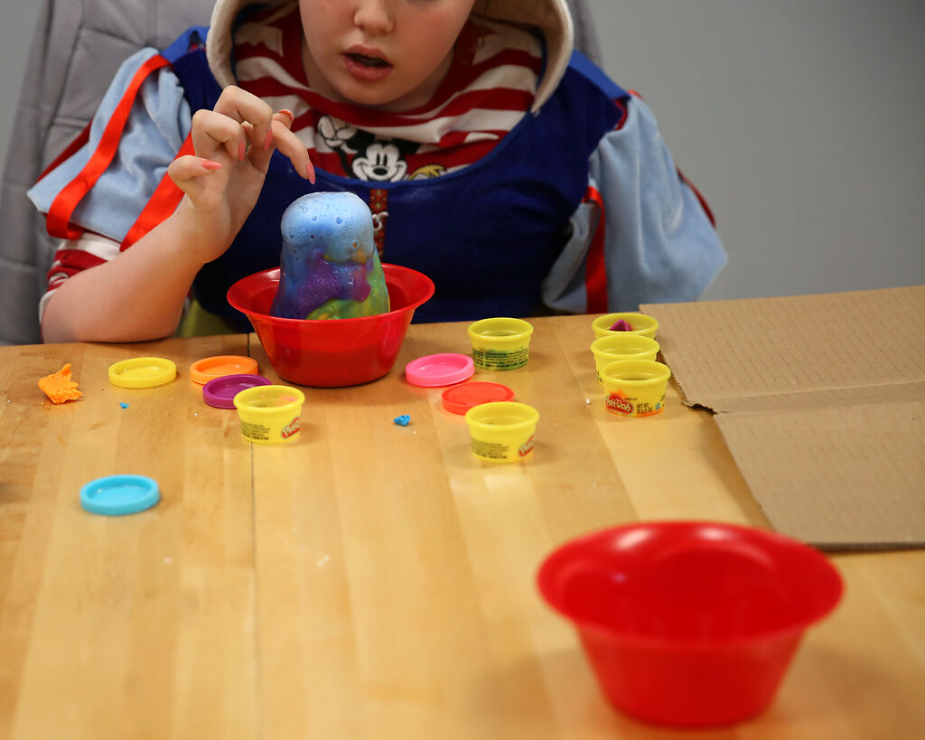 A child staying at Rainbow House pokes the "lava" erupting